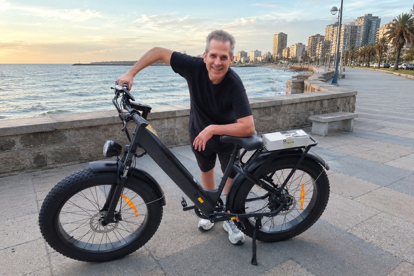 Hombre de más de 40 años sonriendo junto a su bicicleta eléctrica ENGWE en la costanera